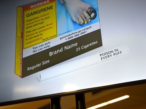 New Health Canada regulations that require warning labels to be printed on individual cigarettes are coming into effect tomorrow. An example of cigarette packaging with expanded warnings, including a warning printed on the cigarettes themselves, is shown on a screen after a news conference, in Ottawa, Friday, June 10, 2022.