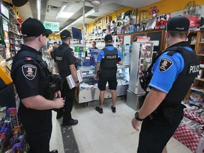 Ljubica Cajan, owner of Tunnel Discount Convenience store in downtown Windsor, chats with Windsor police officers on July 5, 2023. Cajan's store has been a repeated target of vandalism.