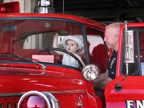 Windsor Professional Fire Fighters Association vice president Wayne Currie puts his granddaughter Katalina Currie in the driver seat of the restored '1959 Elcombe' fire truck on July 19, 2023.