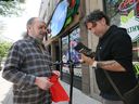Gary Ouellette, 68, left, shows his magic mushroom purchase to Windsor city councillor Renaldo Agostino on Monday, July 3, 2023. The mushrooms were bought at the newly opened Fun Guyz Magic Mushroom Store on Ouellette Avenue in downtown Windsor.