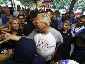 Ontario Premier Doug Ford is swarmed by supporters at Ford Fest at the Ciociaro Club in Tecumseh on Friday, Aug. 11, 2023.