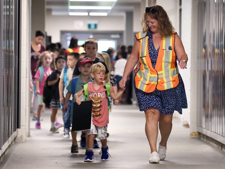  First Grade teacher Linda Fallon leads her students to their classroom at the new Eastview Horizon Public School in Forest Glade on Tuesday.