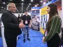 Ontario Premier Doug Ford chats with Andrew Botham and Madeline McQueen from the University of Windsor at the North American International Auto Show in Detroit on Wednesday, September 13, 2023.