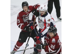 New acquired Windsor Spitfires' defenceman Conor Walton, centre, battles the Guelph Storm's Braeden Bowman, left, and Max Namestnikov during Saturday's game at the WFCU Centre.