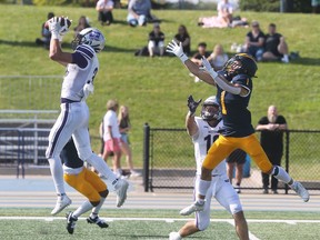 Western Mustangs' safety Jackson Findlay, left intercepts a pass intended for Windsor Lancers' receiver Colby Ginn during Saturday's OUA football game at Alumni Field.