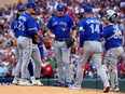 John Schneider of the Toronto Blue Jays takes out pitcher Erik Swanson against the Minnesota Twins.