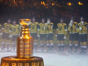 The Stanley Cup is displayed as Vegas Golden Knights players watch the 2023 Stanley Cup championship banner being raised.