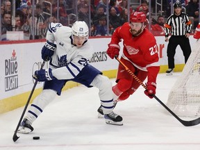 Pontus Holmberg of the Toronto Maple Leafs controls the puck in font of Michael Rasmussen of the Detroit Red Wings during the third period at Little Caesars Arena on January 12, 2023 in Detroit, Michigan.
