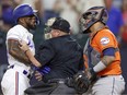 Adolis Garcia #53 of the Texas Rangers argues with Martin Maldonado #15 of the Houston Astros after being hit by a pitch by Bryan Abreu #52 of the Houston Astros during the eighth inning in Game Five of the American League Championship Series at Globe Life Field on October 20, 2023 in Arlington, Texas.