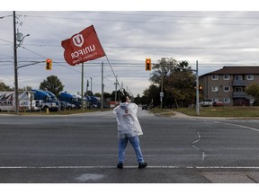 A "Unifor" flag held on a picket line outside General Motors Canada's Oshawa Assembly Complex in Oshawa, Ontario, Canada, on Tuesday, Oct. 10, 2023. Unifor workers have kicked off a strike at General Motors Canada after failing to reach a new contract with the US automaker, idling key factories in Ontario after contract negotiations with the union representing about 4,300 employees failed to bring an agreement.