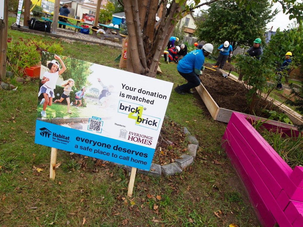 As volunteers work on the garden on Thursday, Oct. 12, 2013, a new sign at the Ford City Community Garden points out that donations to Habitat for Humanity Windsor-Essex — up to $100,000 — will be matched thanks to Everjonge Homes.