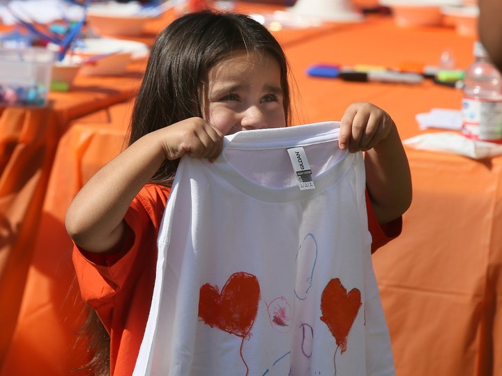  A youngster displays a shirt she painted during National Truth and Reconciliation Day celebrations in Windsor on Saturday, Sept. 30, 2023.