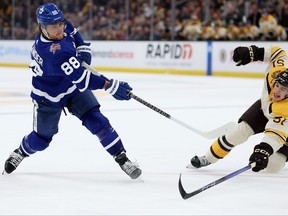 Matthew Poitras of the Boston Bruins dives defending a shot from William Nylander of the Toronto Maple Leafs.