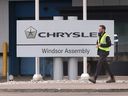 A worker walks by a company sign at the Stellantis Windsor Assembly Plant on Monday, Nov. 6, 2023.