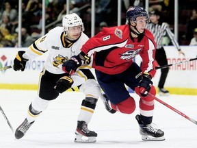 Windsor Spitfires' AJ Spellacy (8) slips past Sarnia Sting's Lukas Fischer (13) in the second period at Progressive Auto Sales Arena in Sarnia, Ont., on Friday, Sept. 29, 2023. (Mark Malone/Postmedia Network)
