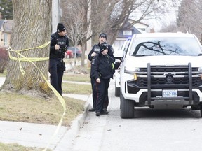 London police officers confer at 1270 Langmuir Ave. in London on Tuesday, Feb. 21, 2023, after a man was shot and seriously injured. (Derek Ruttan/The London Free Press)