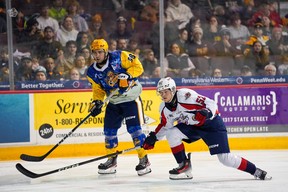 Windsor Spitfires' defenceman Connor Toms, at left, defends against Erie Otters' forward Pano Fimis during Saturday's game.