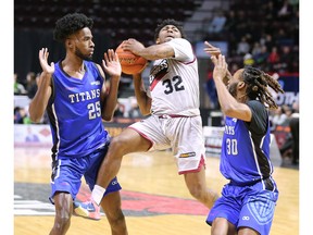 Windsor Express guard Latin Davis, centre, drives between Darian Jones, left, and Michael Bruce, of the Kitchener-Waterloo Titans, during Monday's game at the WFCU Centre.