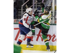 Windsor Spitfires' forward Cole Davis , left, collides with London Knights' defenceman Isaiah George during Friday's game at Budweiser Gardens.