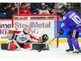 Windsor Spitfires' goalie Max Donoso stretches across the crease to try and take a scoring opportunity away from Guelph Storm forward Jake Karabela.