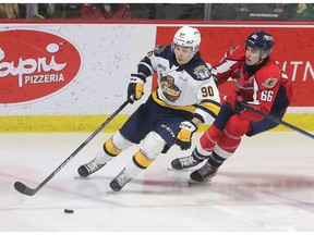 Erie Otters' forward Martin Misiak, left, tries to elude the check of Windsor Spitfires' captain Liam Greentree during Thursday game.
