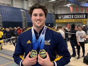 Windsor Lancers' third-year thrower A.J. Stanat shows off his gold medals for the men's weight throw and shot put at the OUA track and field championships at Dennis Fairall Fieldhouse on Saturday.