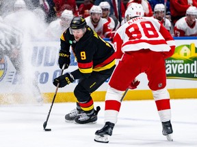 Vancouver Canucks' J.T. Miller (9) skates with the puck as Detroit Red Wings' Patrick Kane (88) defends during the first period of an NHL hockey game, in Vancouver on Thursday, Feb. 15, 2024.