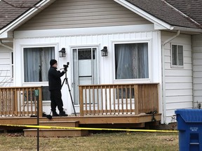A Chatham-Kent police forensic officer takes photographs outside a Towanda Boulevard home in Erie Beach Wednesday, a day after a 40-year-old Windsor man was found dead inside the home. (Ellwood Shreve/Chatham Daily News)
