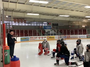 Essex Red Raiders' head coach Cory McAiney, far left, goes over practice details at the Essex Centre Sports Complex as the team prepares for the OFSAA girls' A/AA hockey championship, which begins Tuesday.