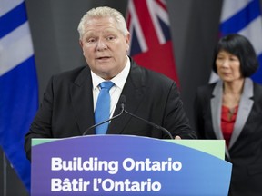 Ontario Premier Doug Ford, left, speaks during a press conference regarding housing development in the Greater Toronto Area, as Toronto Mayor Olivia Chow, right, looks on at Toronto City Hall, in Toronto on Thursday, Feb. 22, 2024.