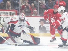 Windsor Spitfires' goaltender Joey Costanzo (33) tries to gather the puck while teammate Anthony Cristoforo (74) moves into to assist and Sault Ste. Marie Greyhounds' forward Tate Vader (9) moves closes in during Saturday's OHL game at the GFL Memorial Gardens.