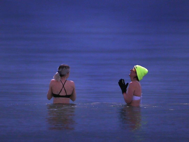  Two women brave the cold water of Lake Erie while watching the eclipse on Monday, April 8, 2024 at Seacliff Beach in Leamington.