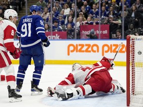 Toronto Maple Leafs centre John Tavares (91) watches the 69th career goal of teammate Auston Matthews, not shown, fly past Detroit Red Wings goaltender James Reimer (47) during second period NHL hockey in Toronto, Saturday, April 13, 2024.