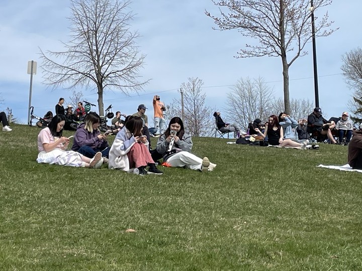  Hundreds of people gathered at Seacliff Park Monday, April 8, 2024 to watch the total eclipse. Some took advantage of the grassy slope to look up at the sun.