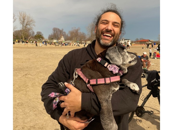  Adriano Ciotoli holds his dog Zoey at Seacliff Beach shortly after the total eclipse passed Monday, April 8, 2024.