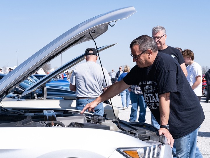  Local Mustang owner Keith Dupuis looks under the hood of one of the iconic muscle cars during the 60th anniversary gathering on Sunday at Ford’s Essex Engine Plant.