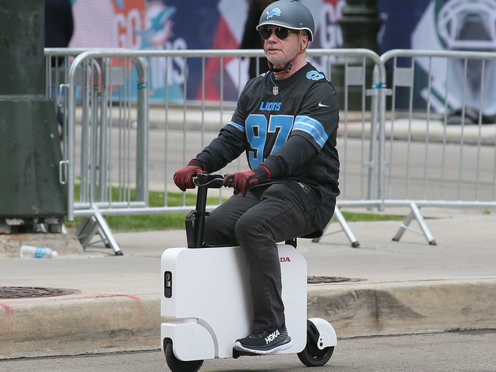 A Detroit Lions fan rides a scooter in downtown Detroit on Wednesday, April 24, 2024. A number of streets are blocked off to traffic to accommodate large expected crowds until Saturday during the NFL Draft.
