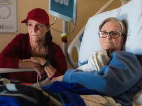 Michele Campeau, left, visits with her mother, Ruth Poupard, 83, at Hotel-Dieu Grace Healthcare where she is recovering from a broken hip, in Windsor, Ont., on Wednesday, April 3, 2024. Poupard also suffers from dementia and requires 24-hour care.