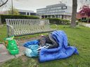 On the same day Windsor leaders announced a new initiative to revitalize the downtown — including measures to address homelessness — a man sleeps near City Hall on Tuesday, April 23, 2024.