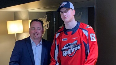 Windsor Spitfires' general manager Bill Bowler, left, looks on as first-round pick Ethan Belchetz officially signs on with the club on Saturday at the WFCU Centre.
