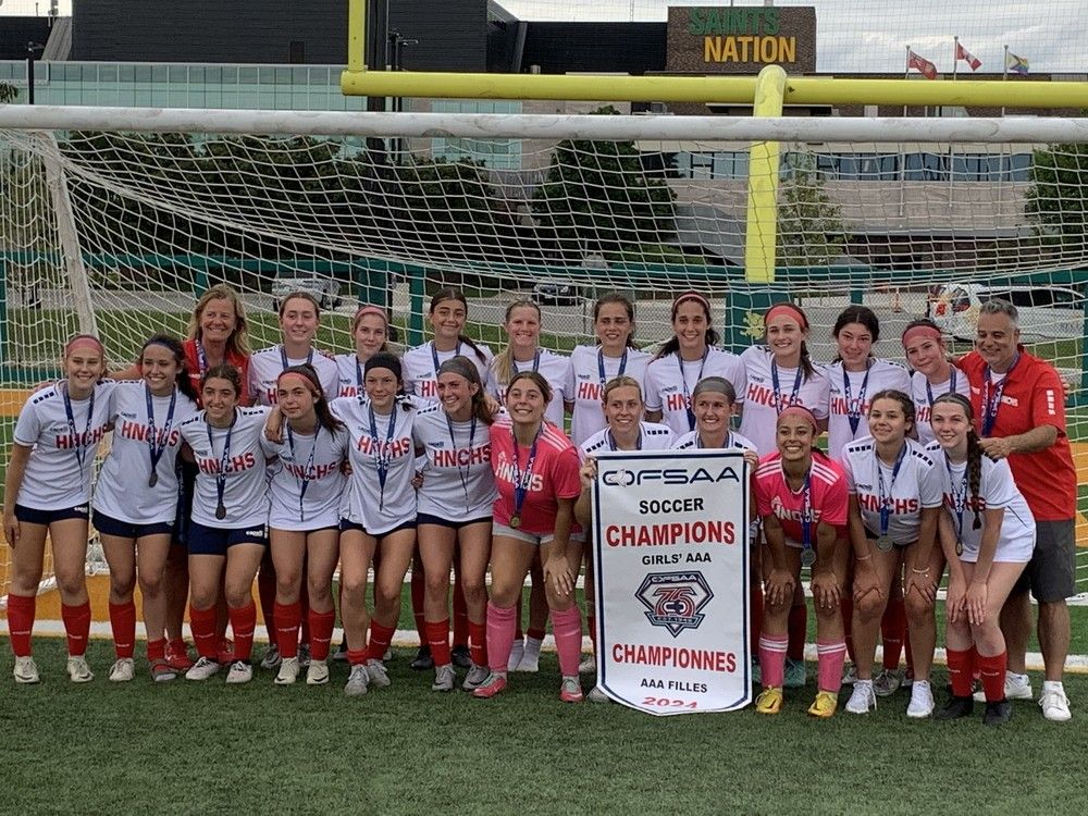 The Holy Names Knights pose with the championship banner after Saturday's&nbsp; 2-0 win over St. Thomas Aquinas in the gold-medal game at the OFSAA girls' AAA soccer championship, which was played at Acumen Stadium.