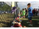 Essex County residents bring flowers, teddy bears, and other items to a vigil held at the Harrow Soccer Complex on Sunday, June 23, 2024, for a local family of four found dead on Thursday.