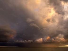 Ominous clouds from a rain storm are lit up by the setting sun on Lake Erie in this file photo. (Postmedia Network files)