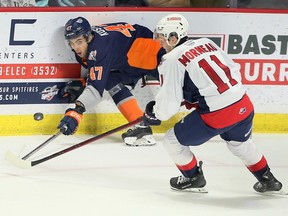 El defensa de los Windsor Spitfires, Tanner Winegard, izquierda, lucha con el delantero de los Flint Firebirds, Matthew Wang, frente al portero de los Windsor, Joey Costanzo, durante el partido del martes en el Centro WFCU.