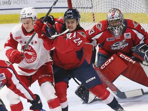 Windsor Spitfires' defensive player Carson Woodall, Cnetre, attempts to clear Sault Ste. Marie Greyhounds forward Brady R Smith came from Windsor goalkeeper Joey Costanzo in a game Thursday at the WFCU Center.