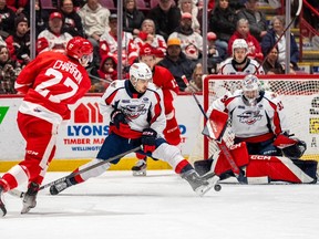 Windsor Spitfires' defensive player Josef Eichler (center) slipped away, stopping Sault Ste from a shot. Mary forward Jordan Charron (27) can only reach Windsor goalkeeper Joey Costanzo.