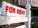 A white and red sign advertises a house for rent.