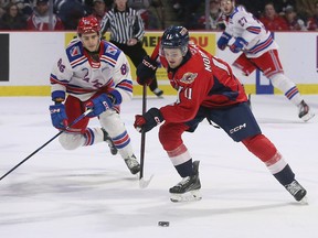Windsor Spitfires' forward Noah Morneau, at right, tries to pull away from a check by the Kitchener Rangers' Luca Romano during Thursday's game at the WFCU Centre.