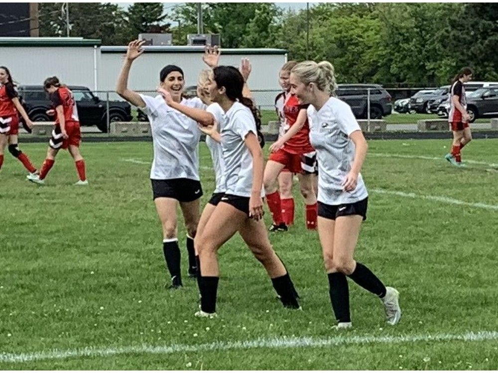  the l’essor aigles’ jasmine dado, centre, celebrates with teammates after scoring a goal during thursday’s swossaa senior girls’ aa soccer final. l’essor won the game 3-0.
