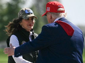 U.S. President Donald Trump, right, speaks with Michigan Gov. Gretchen Whitmer after arriving at Selfridge Air National Guard Base in Warren, Mich., on April 29, 2025.